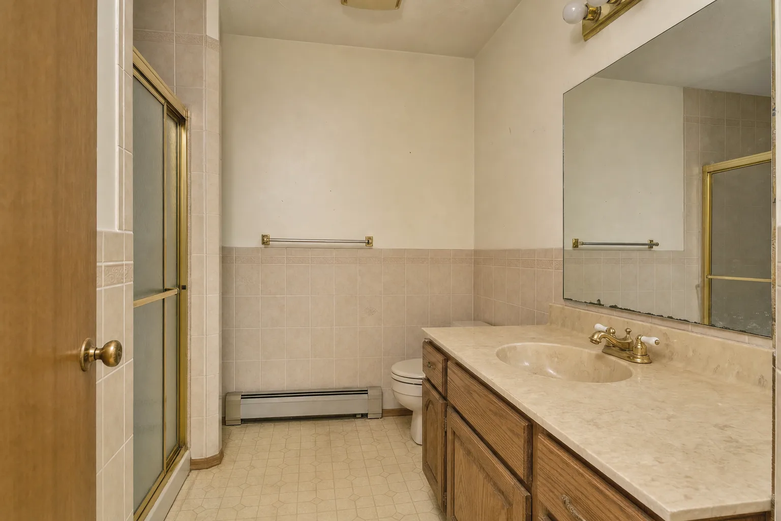 Bryn Mawr primary bathroom before renovation with dated tile and fixtures