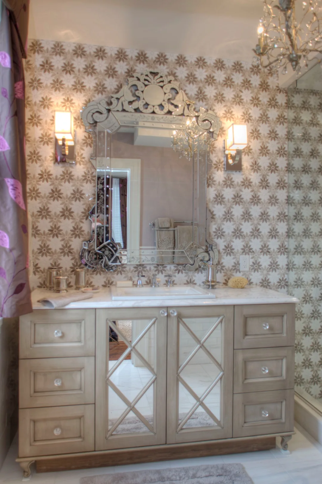 Glamorous Cape May teen girl ensuite bathroom with a mirrored vanity, ornate Venetian mirror, floral marble mosaic feature wall, and a crystal chandelier