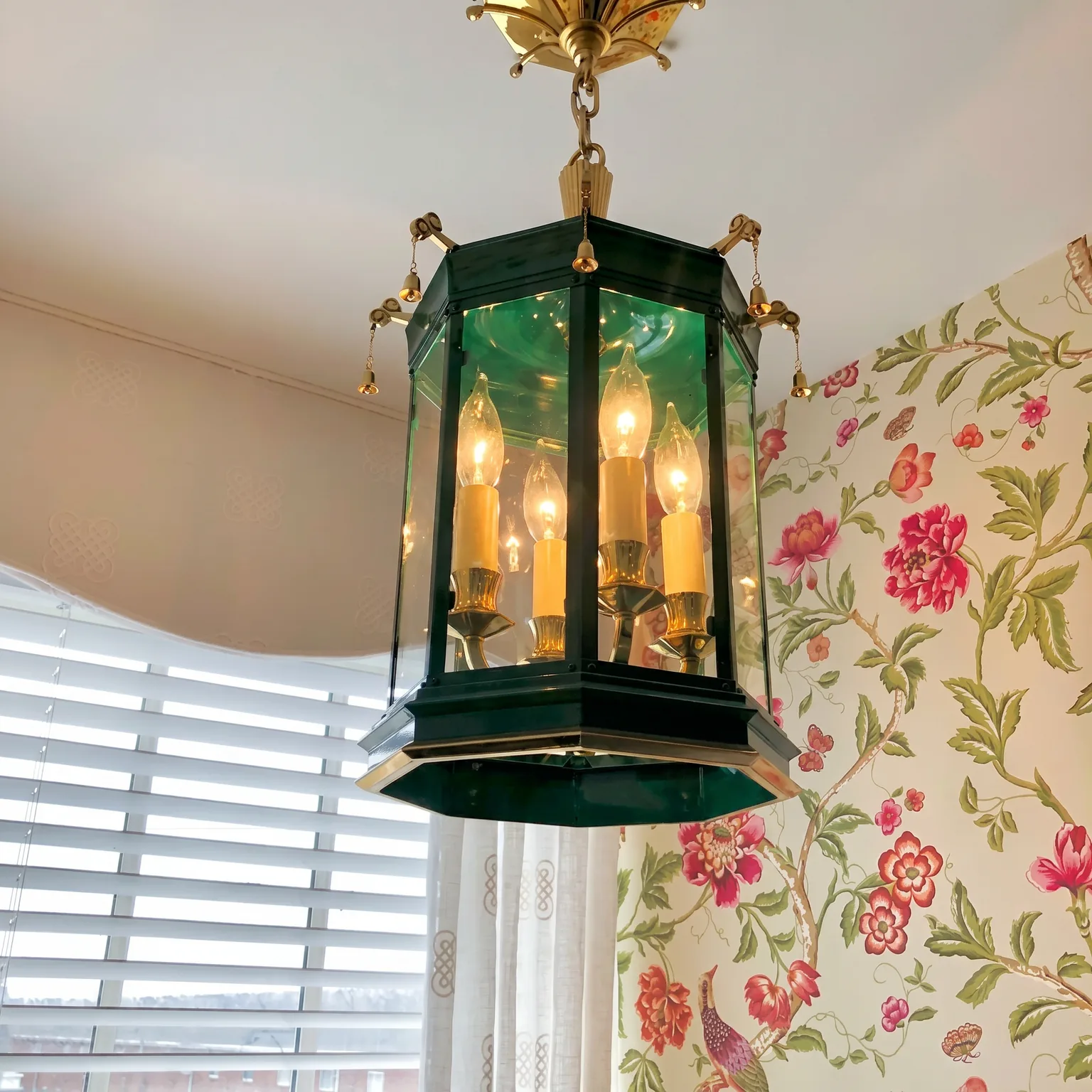 Detail of the green glass and brass Charles Edwards hexagonal lantern pendant against the floral chinoiserie wallpaper in the Cape May bathroom