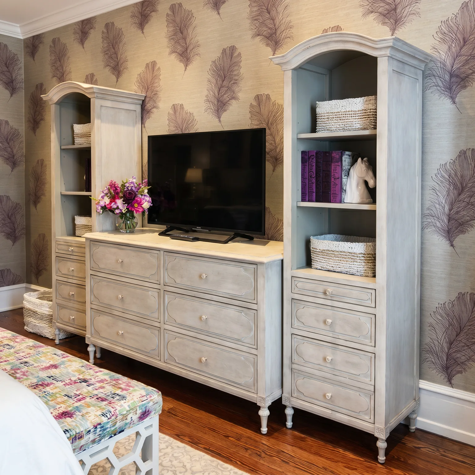 Cape May ensuite dresser wall after renovation with twin grey-washed arched bookcases flanking a media dresser against feather grasscloth