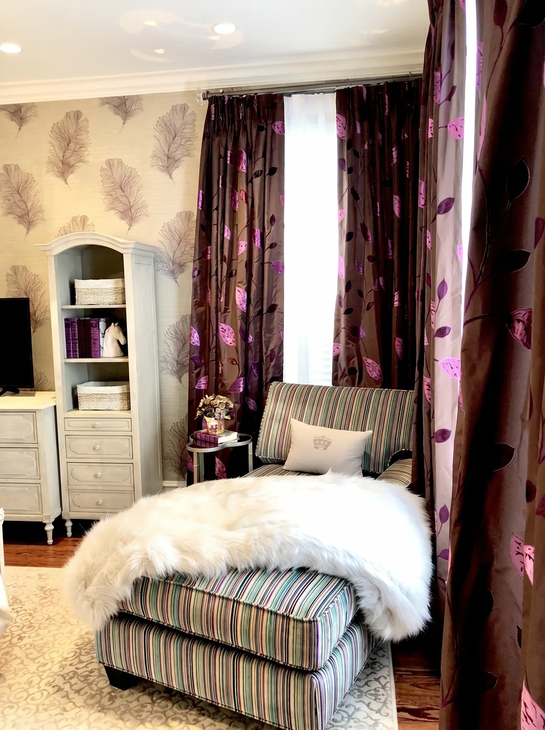 Reading nook in the Cape May ensuite with a striped chaise, grey arched bookcase, and metallic leaf-print drapery