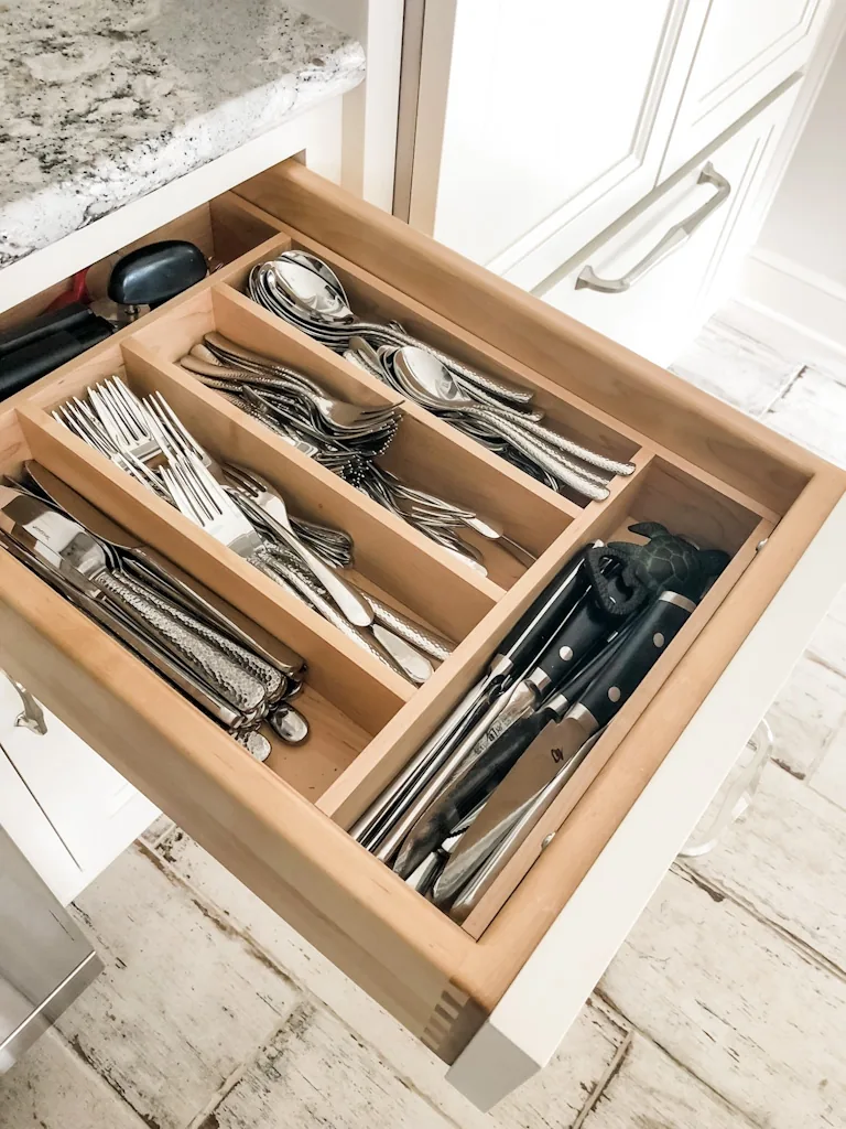 Custom dovetailed wood flatware drawer organizer with divided compartments for utensils and knives in the Churchville kitchen