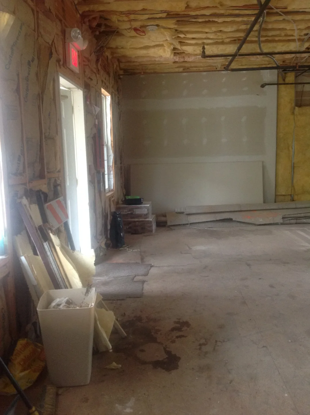 Bare stud walls and exposed insulation before the ground-up buildout of an eye doctor’s office