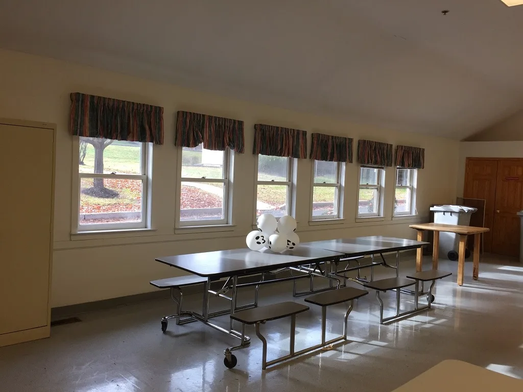 Bare institutional cafeteria room before its transformation into a residential healthcare facility for children
