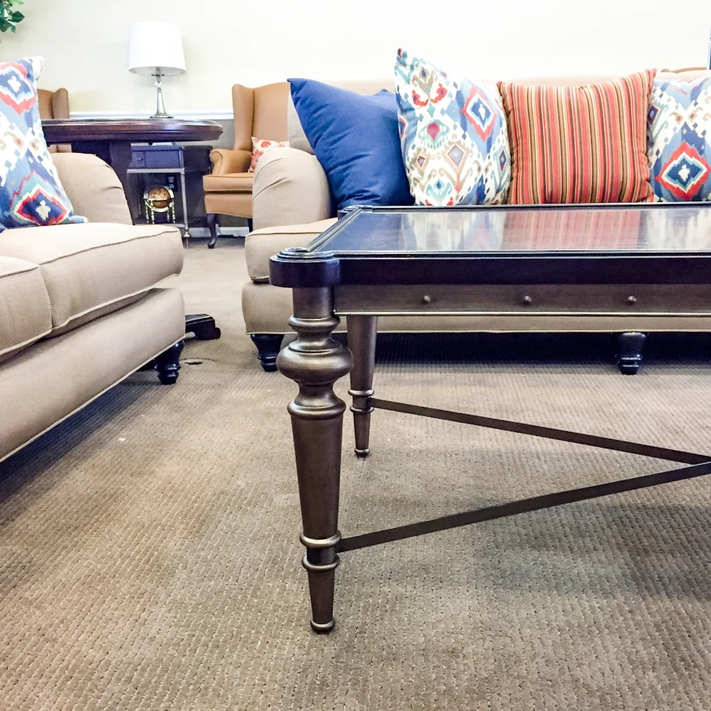 Warm senior living community lounge with custom built-in bookcases, layered textiles, and traditional furnishings