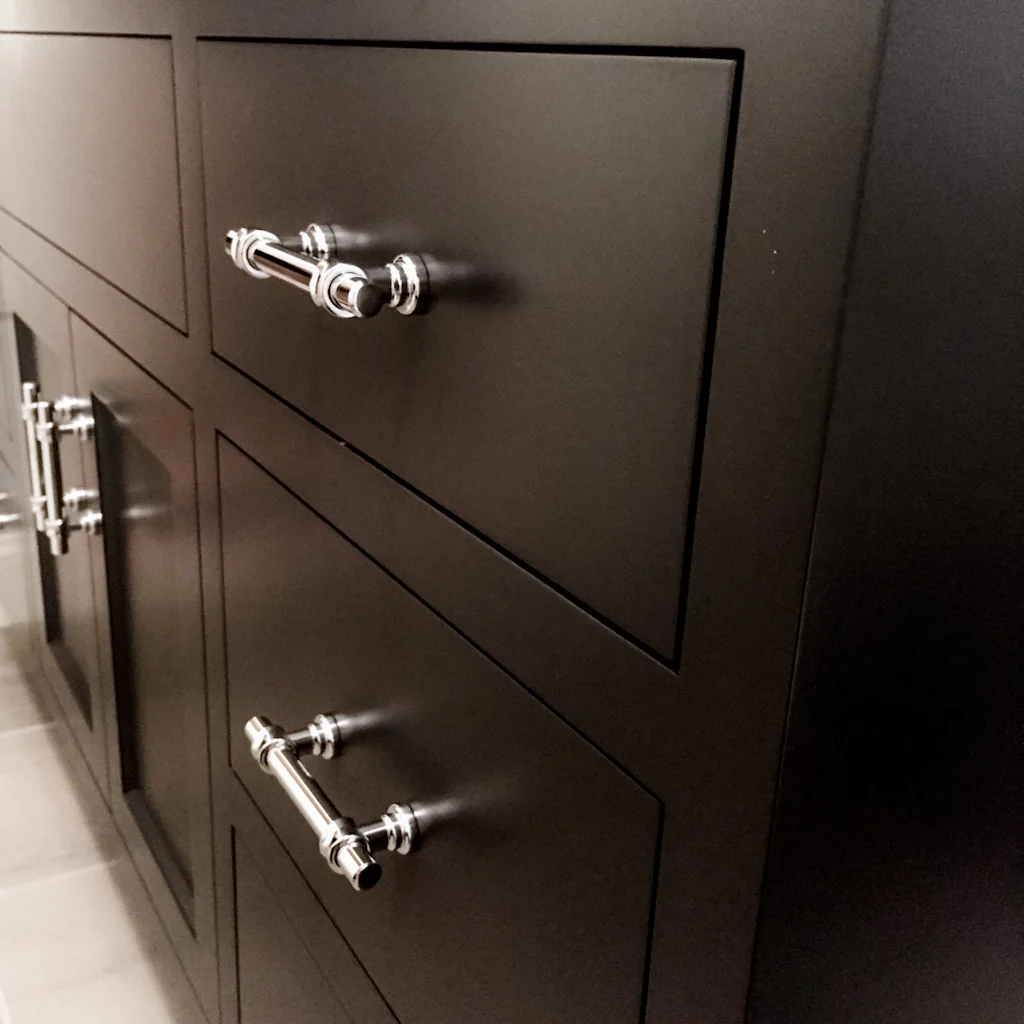 Detail of the polished chrome industrial-style bar pulls on the navy shaker drawer fronts of the custom Nina Green Signature Series vanity in the Holland bathroom